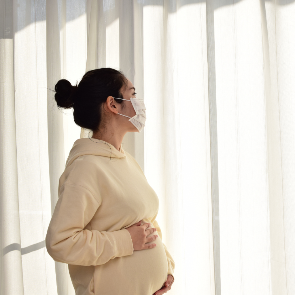 zdjęcie kobieta w ciąży w maseczce - smog płodność