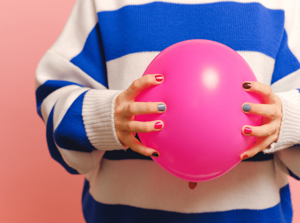 zdjęcie kobiety trzymającej różowy balon w nawiązaniu do tematu: sibo a endometrioza