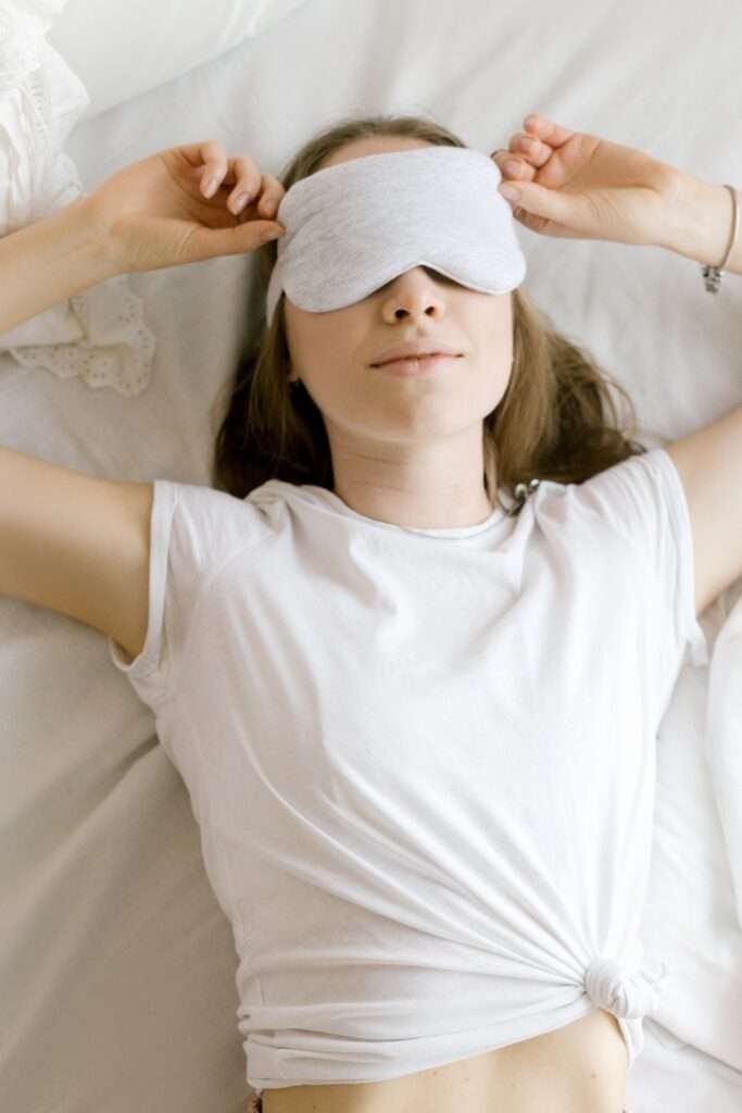kobieta z opaską na oczach w nawiązaniu do odpoczynku w temacie: co nasila endometriozę i jej obajwy