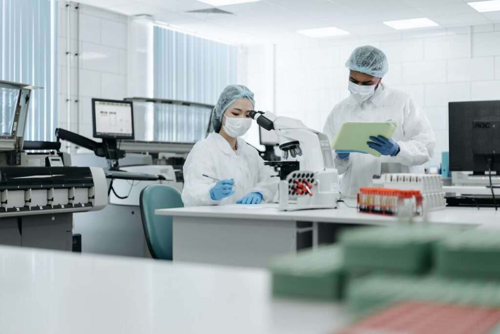 dwóch naukowców w laboratorium, jako nawiązanie do naukowców badajacych czy bakterie powodują endometriozę